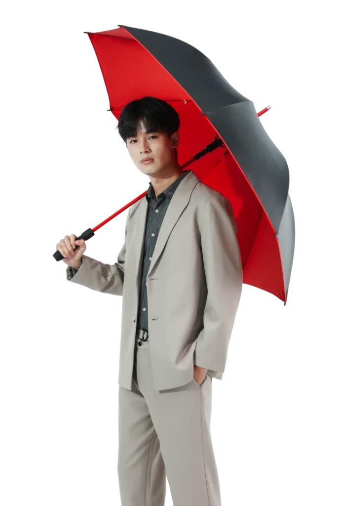 Foto de estilo de vida com modelo usando um guarda-chuva reto vermelho e preto.